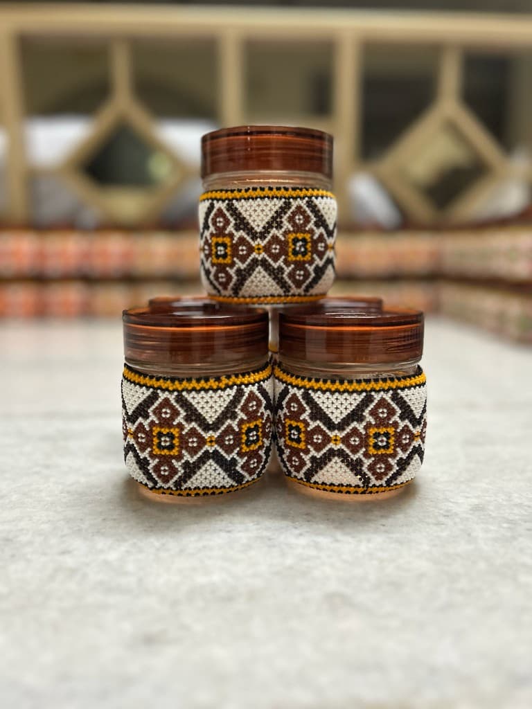 Brown and black beaded jar held in hand sophisticated minimal palette