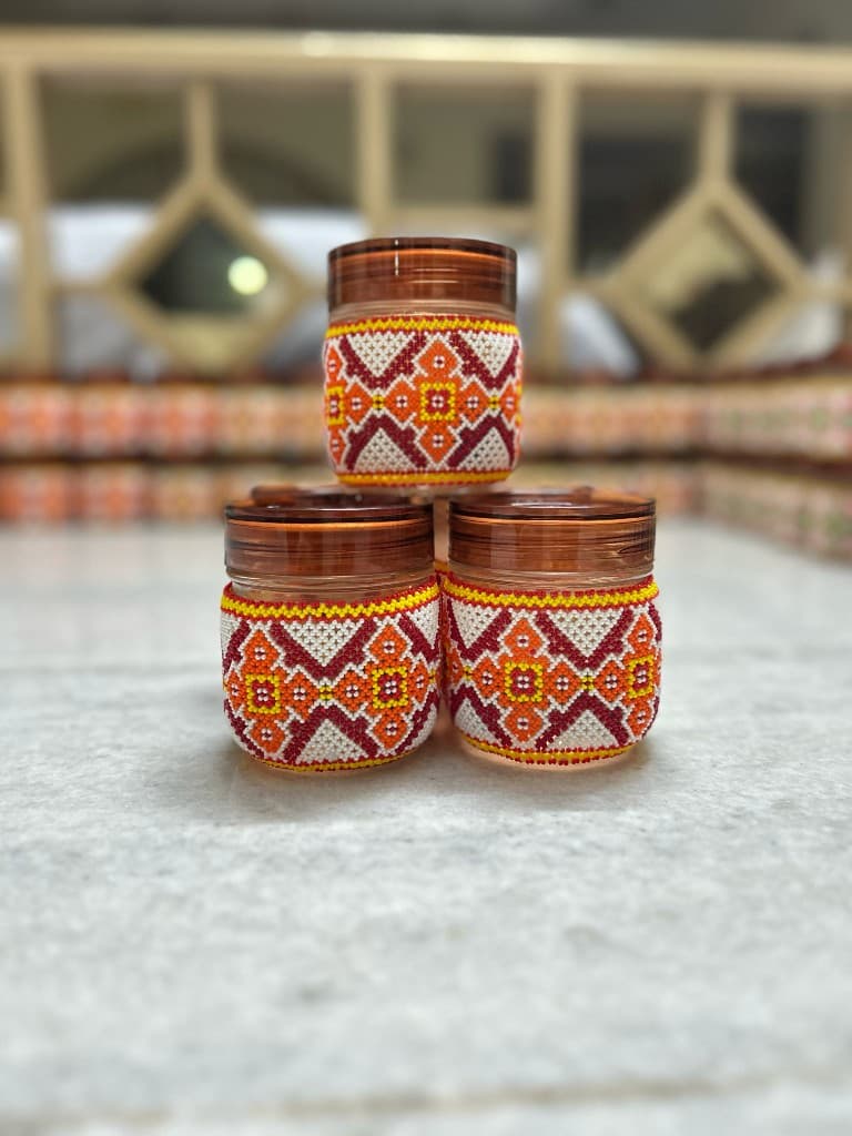 Seven different colourway beaded jars in a flat lineup full colour range