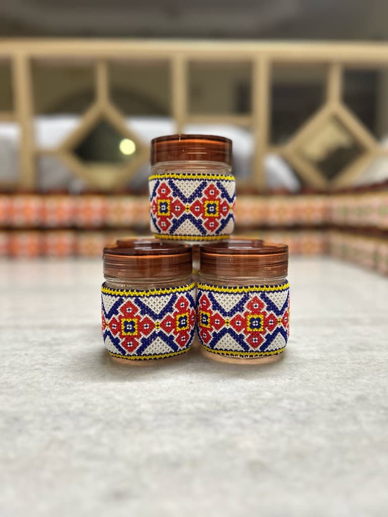 Large blue and orange beaded jar held in hand, full bead coverage top to bottom