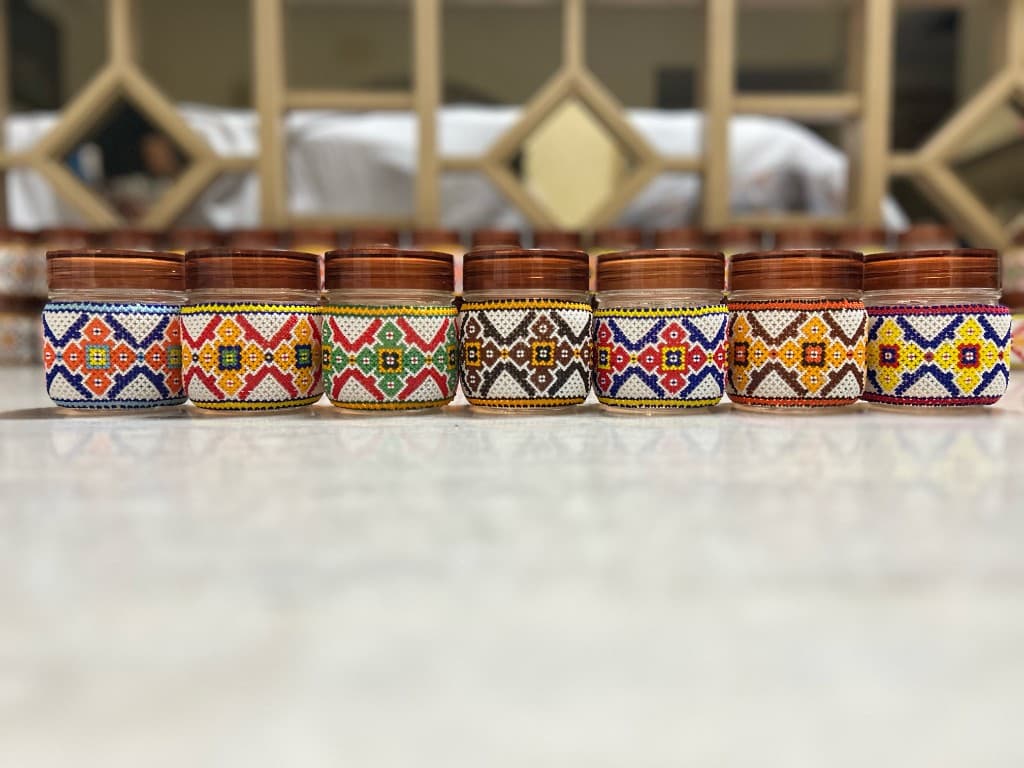Full collection of multicolour beaded jars in a flat front row