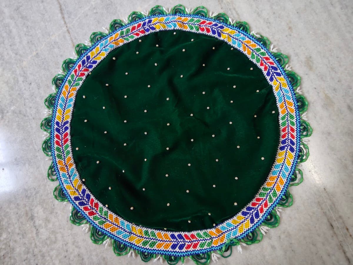 Beaded Laddu Gopal singhasan with colourful beadwork on red background