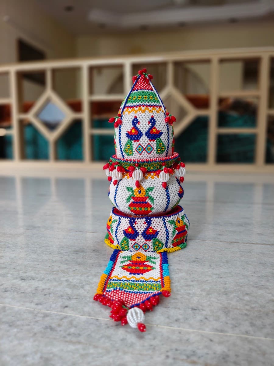 Moti bharat loti shrifal — beaded coconut on a loti vessel with peacock motifs and hanging tassels