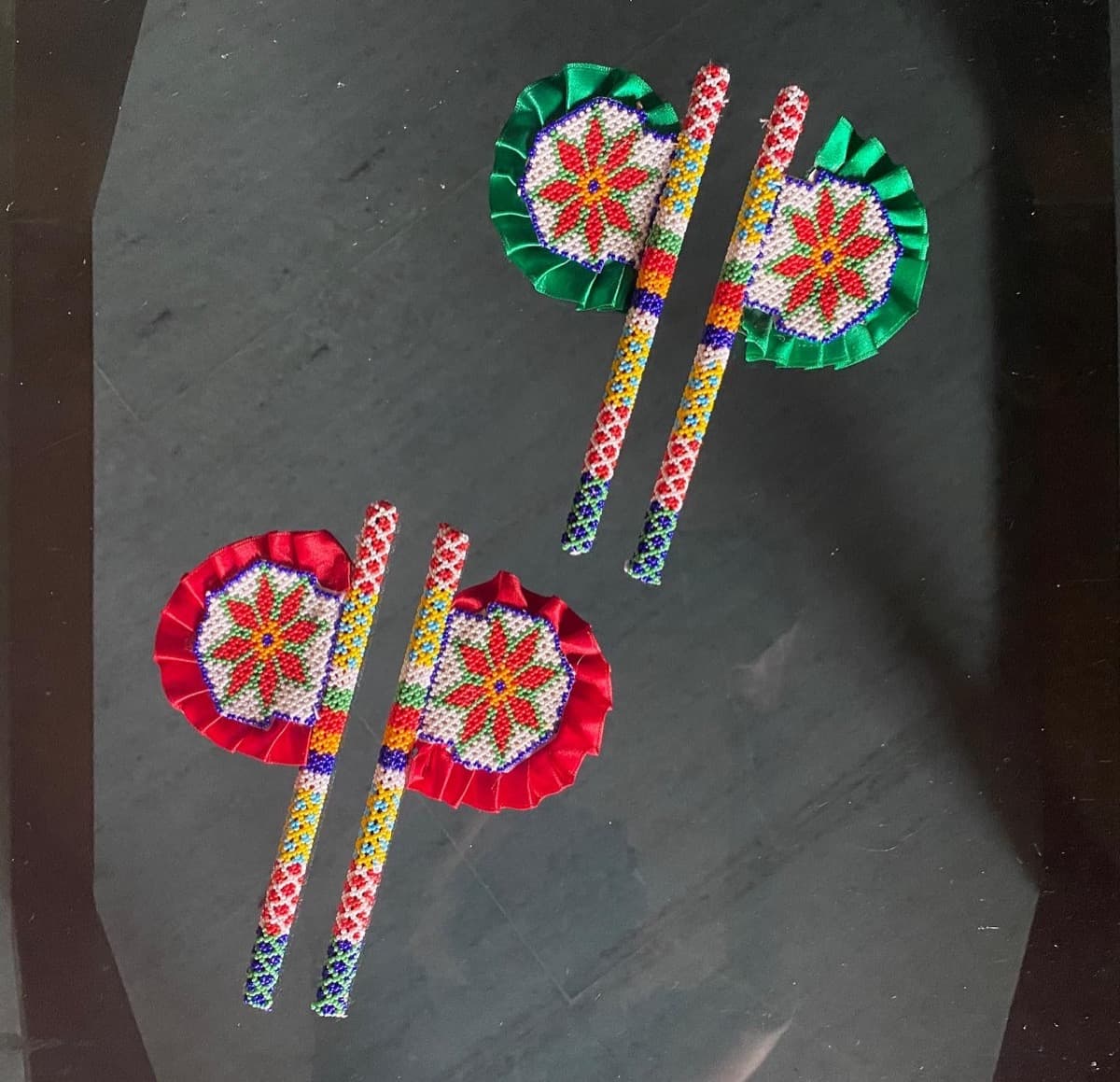 Two pairs of moti bharat vinjana (hand fans) with floral patterns and satin ribbon borders in red and green
