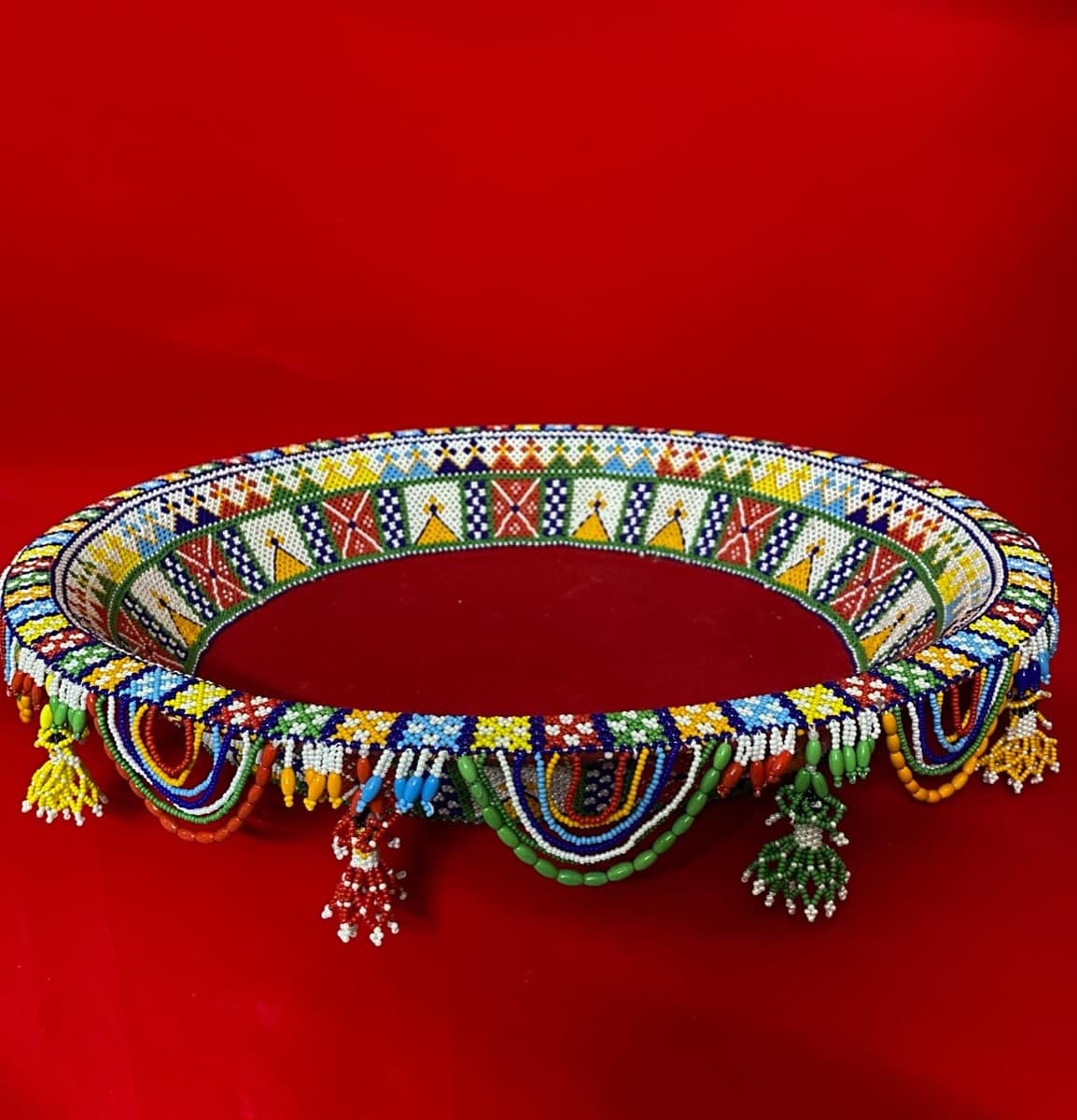 Round beaded tras with vibrant multicoloured beadwork patterns and hanging bead tassels